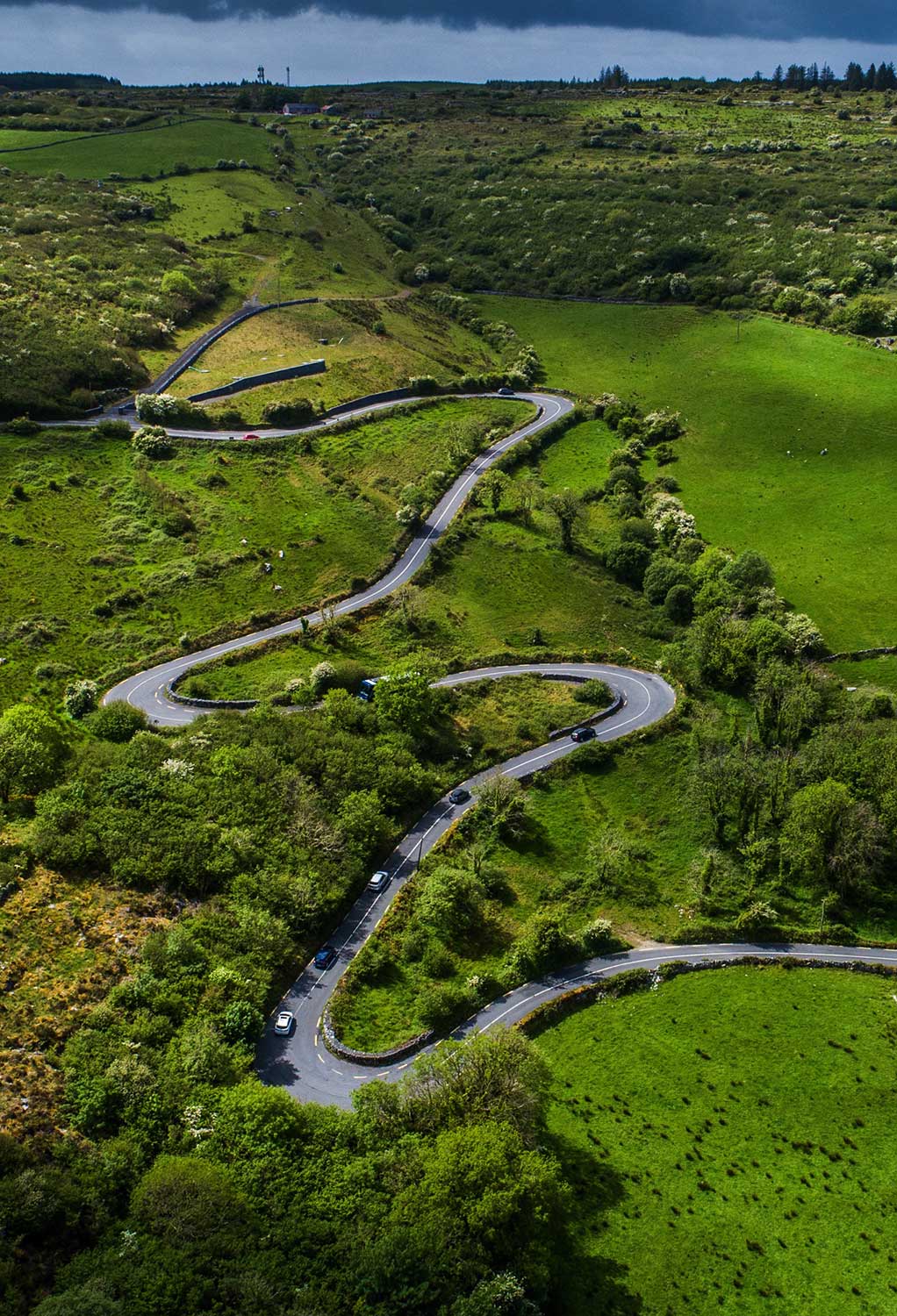 a winding road running up through fields in County Clare Ireland